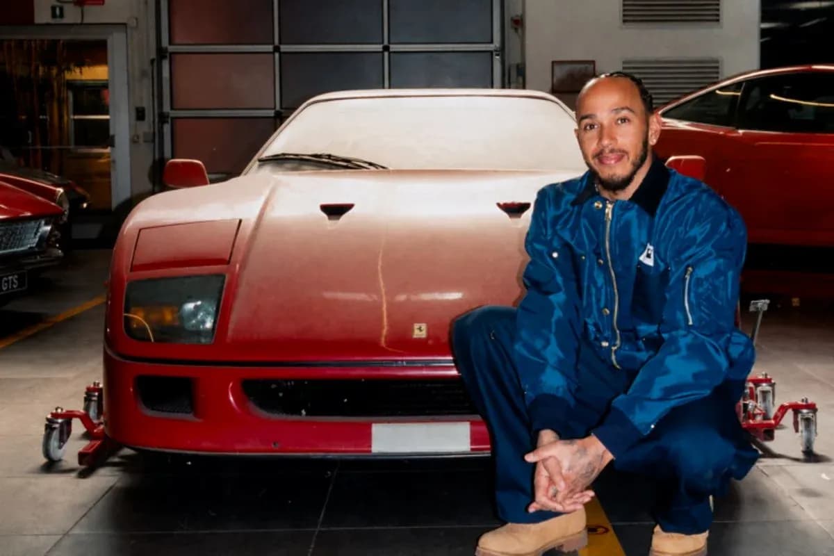 Hombre agachado junto a un Ferrari rojo en taller Hombre agachado junto a un Ferrari rojo en taller