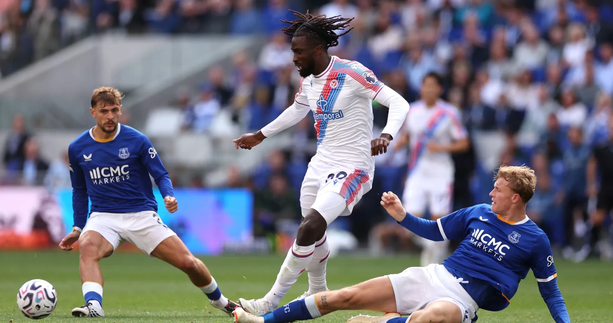Jugador de Crystal Palace driblando a dos rivales de Everton Jugador de Crystal Palace driblando a dos rivales de Everton